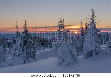 Fantastic orange evening landscape glowing by sunlight. Dramatic wintry scene with snowy trees. Kukul ridge, Carpathians, Ukraine, Europe. Merry Christmas!
