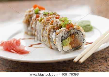 Fancy Philadelphia sushi roll topped with roe sushi sauce and chopped scallions