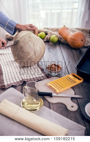 Woman in kitchen making prepares a pie with pumpkin, selective focus