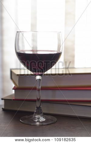 Glass of wine pencils and books in this retro creative writing and relazation themed desk top