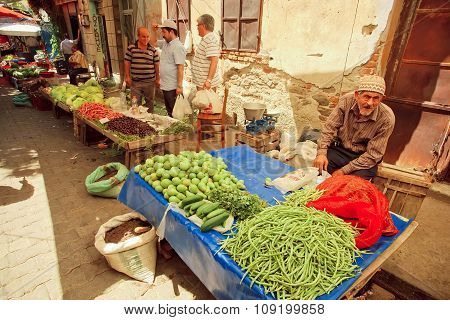 Old Man Sells Herbs, Beans And Pears On Rustic Street Market In Turkey