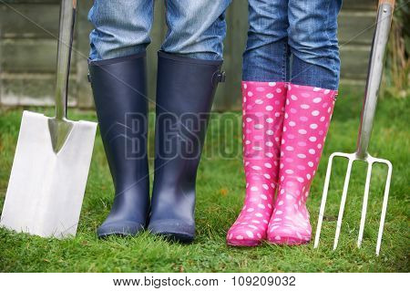 Close Up Of Couple Gardening Holding Spade And Fork