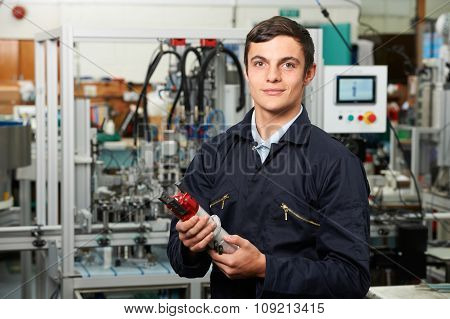 Apprentice Engineer Checking Component In Factory