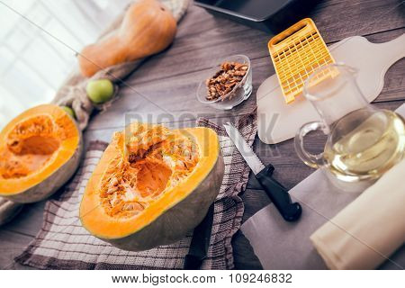 Woman in kitchen making prepares a pie with pumpkin, selective focus