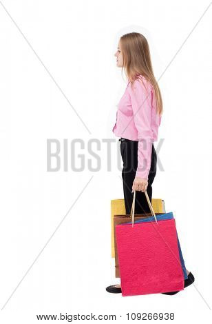 back view of going woman with shopping bags. beautiful girl in motion. backside view of person.  Isolated over white background. girl in the pink shirt is left bent under weight of bags.