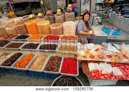 Elderly Woman Sells Dried Fruit And Cottage Cheese On Rustic Street Market