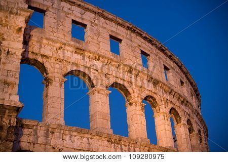 Roman colosseum in evening light and blue sky background