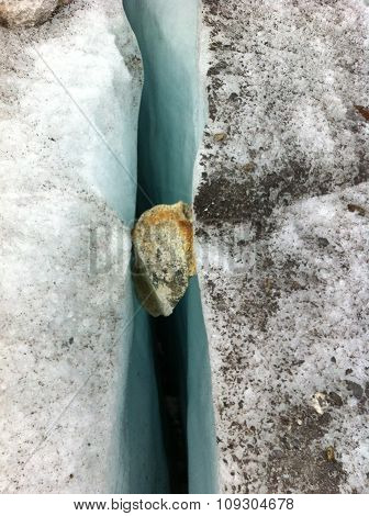 Stone stuck in a glacier crevasse