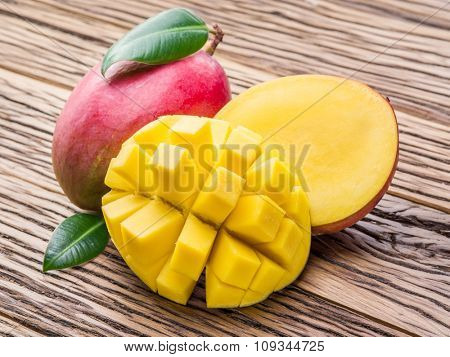 Mango fruit and mango cubes on the wooden table.