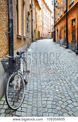 Old street in Stockholm, Sweden. Shallow DOF, focus on the bike