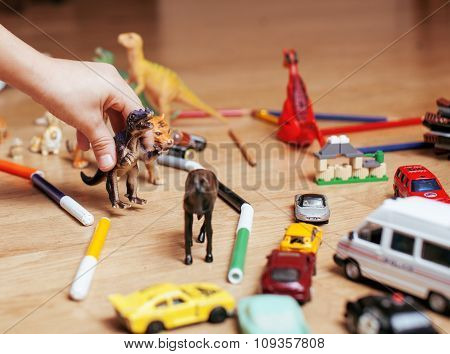 children playing toys on floor at home, little hand in mess