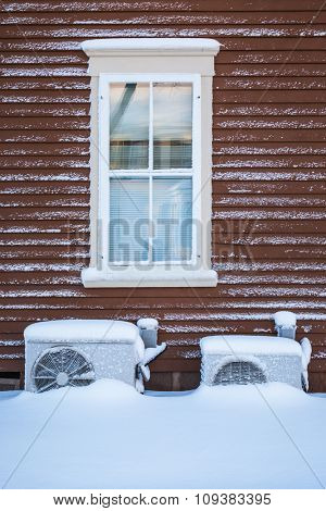 Two residential heat pumps buried in snow.
