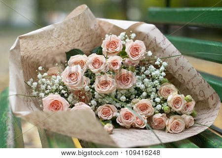 Beautiful bouquet in the paper on the bench