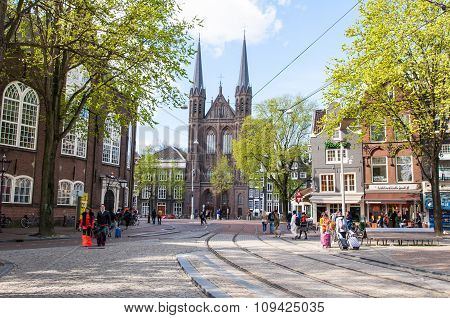 AMSTERDAMNETHERLANDS-APRIL 27: Krijtberg Kerk facade in the distance on King's Day on April 272015 in Amsterdam Netherlands. De Krijtberg Kerk is a Roman Catholic church at the Singel canal.