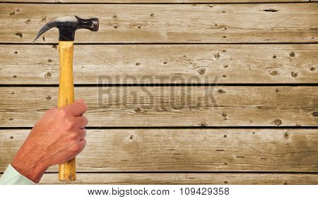 Hand of handyman with a hammer. House renovation and construction.