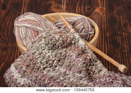 Knitting of Scarf or Snood. Yarn Balls. Wooden Knit Needles