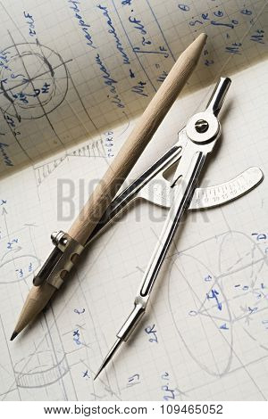a pair of compasses on a trigonometry papers