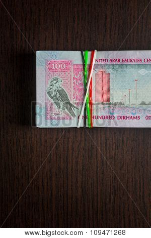Bundle of Aed 100 wrapped with rubber band.
