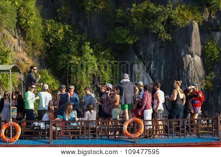 HALONG BAY, VIETNAM, DECEMBER 18, 2014 : Tourists passengers of a cruise around the Halong Bay are enjoying taking photos and having fun on the boat, Halong Bay, Vietnam