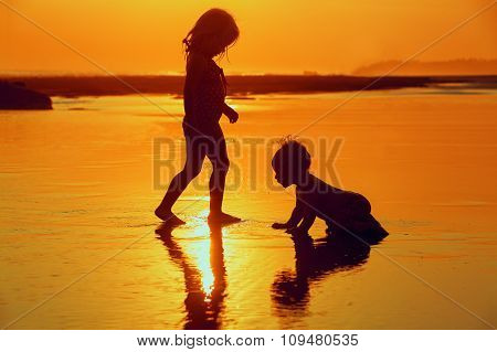 Children Playing With Fun On The Sunset Sea Beach
