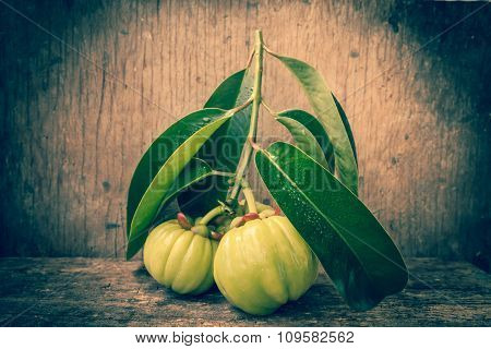 Fresh Garcinia Cambogia On Wooden Background. Vintage Tone.