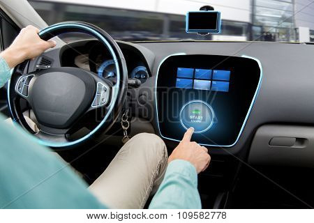 transport, road trip, car driving, technology and people concept - close up of man driving car and pushing start engine button on board computer