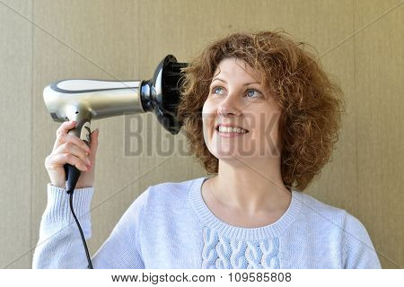 Woman doing curls with  hairdryer and diffuser