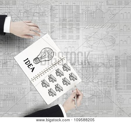 Businessman hands drawing money making formula in notepad
