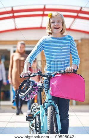 Female Pupil Pushing Bike At End Of School Day