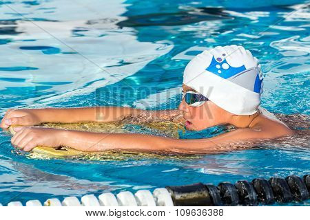 Boy Swimming With Kick Board.