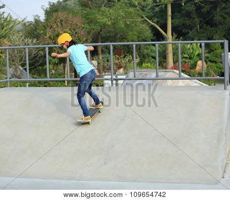 young woman skateboarder skateboarding at skatepark