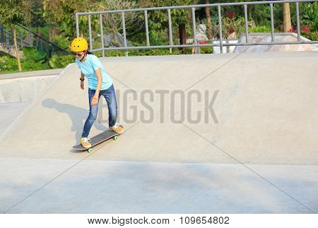 young woman skateboarder skateboarding at skatepark