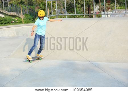 young woman skateboarder skateboarding at skatepark