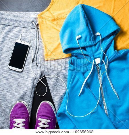 Sport clothes, shoes and mobile phone with headphones. Top view
