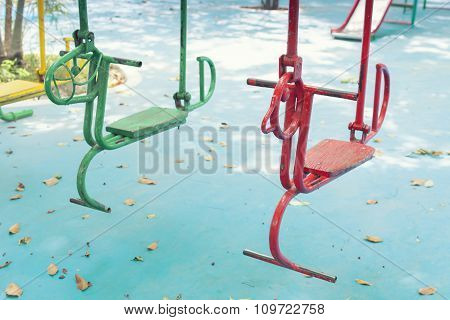 Empty hourse swings on summer kids playground