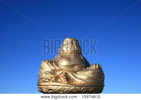 Золотой Buddah на фоне голубого неба