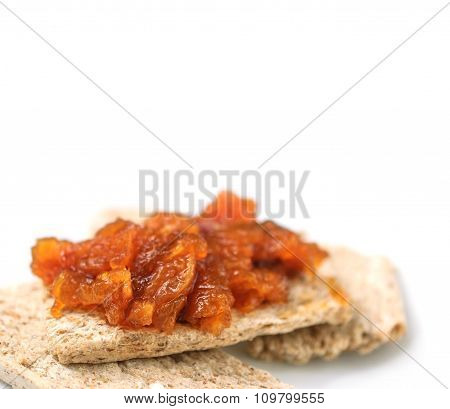 Canapes with homemade onion chutney with ginger and red pepper on a white background. Selective focus on a chutney.
** Note: Shallow depth of field