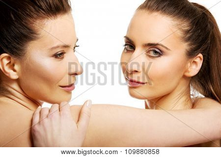 Two attractive sisters with make up embracing.