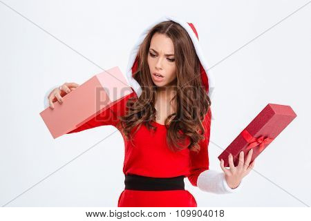 Disappointed shocked curly young woman in red santa claus costume with hood got empty gift over white background