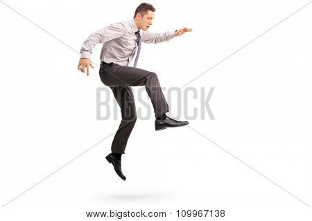 Full length profile shot of a young businessman jumping in the air shot in mid-air isolated on white background