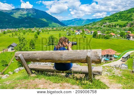 A Young Girl Takes Pictures On A Wooden Bench Near The Sources Of Ali Pasha.