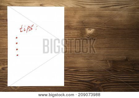 Tips note paper page with copy space on wooden desk table surface background.