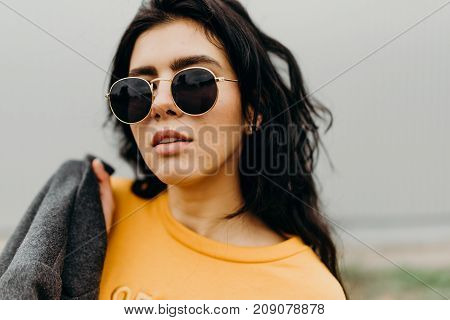 Portrait Of Stylish Modern Young Curly Woman In Coat Sunglasses