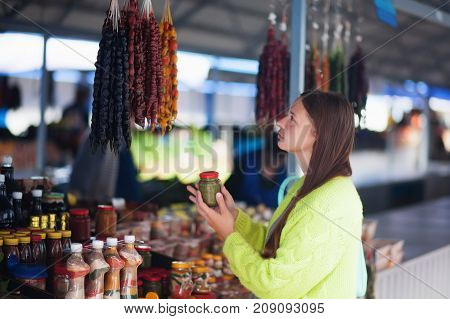 Young woman at the bazaar buying food ingridients.