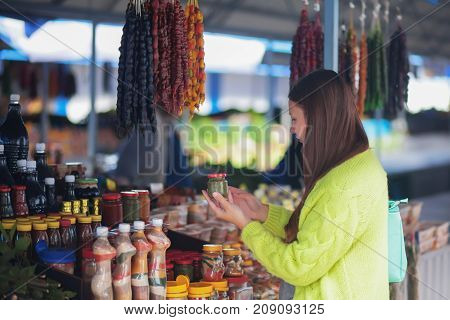 Young woman at the bazaar buying food ingridients.