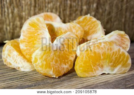 Mandarin slices on wooden table as background