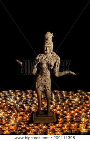 Diwali. Traditional bronze statue of Hindu Goddess Lakshmi or Laxmi in flaming candle light. Festival of Lights.