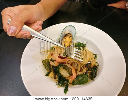 The woman eating delicious spaghetti sticky and soft lines. Good smells of dried chilies and basil leaves.