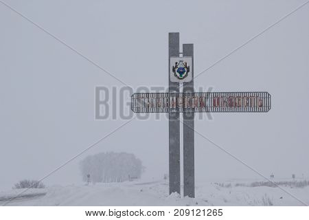 TYUMEN OBLAST, RUSSIA - JANUARY 13, 2017:Heavy snowfall. Road sign on the border of Kurgan region and Tyumen region. The inscription on the sign 