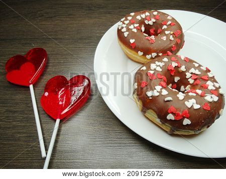 hearts red lollipops and chololate donuts love concept valentine's day on wooden background